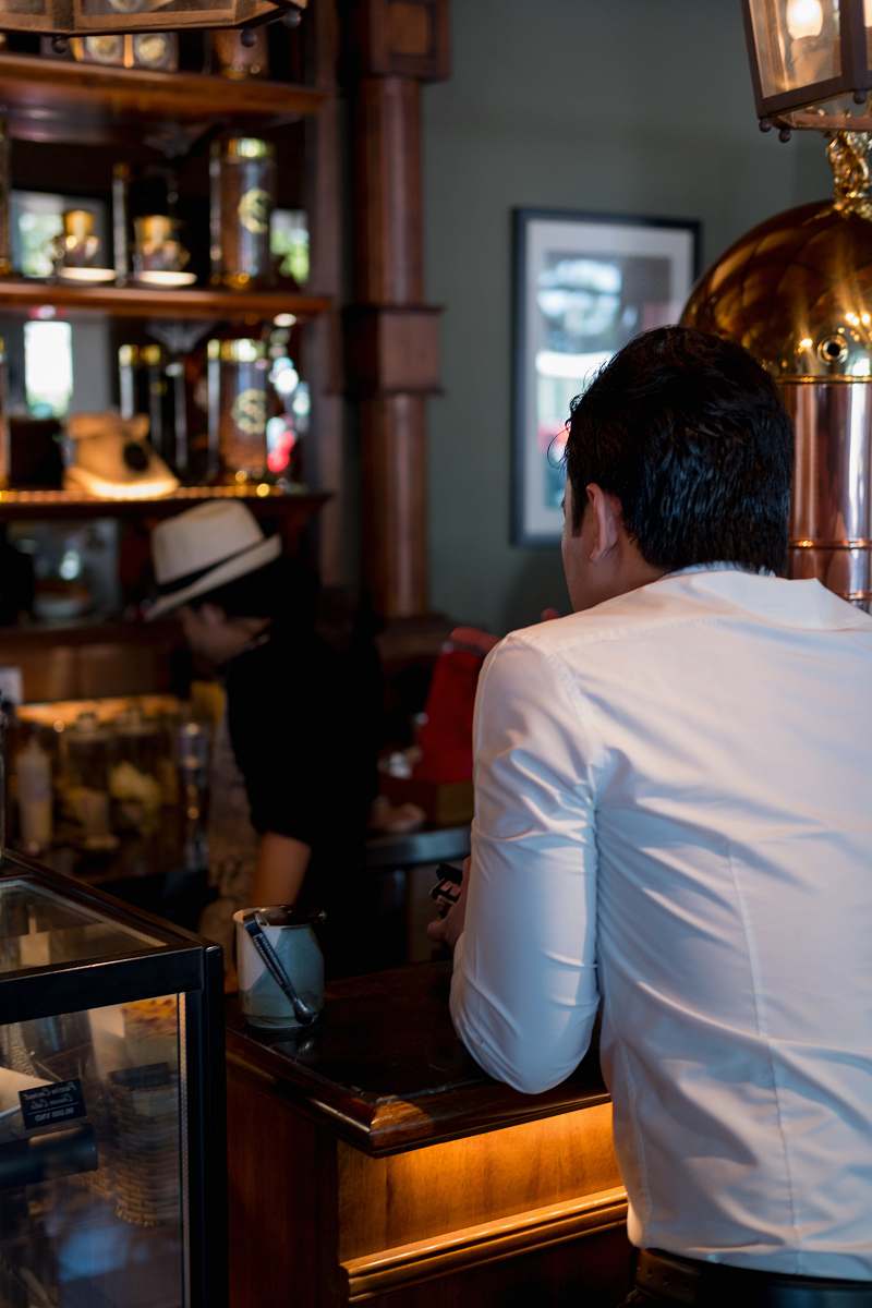 human man wearing white dress shirt leaning on brown wooden table ho chi minh city