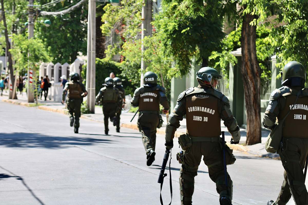 human running and walking men in police uniform holding rifles during daytime apparel