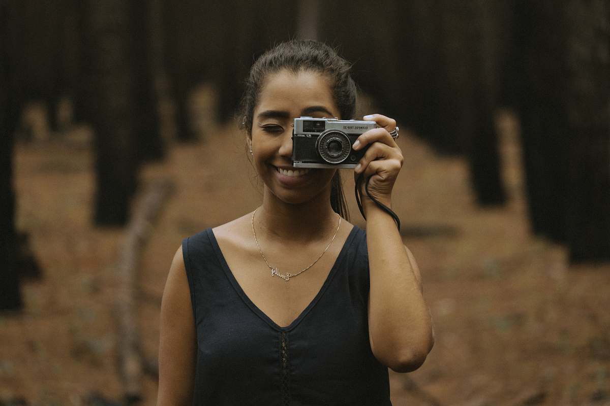 human woman holding silver DSLR camera during daytime people