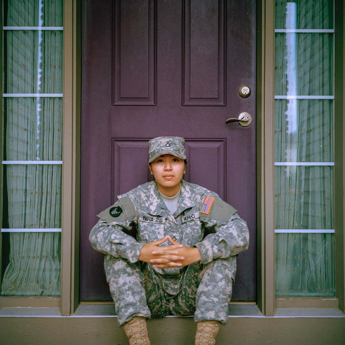 military woman sitting in front of closed door door