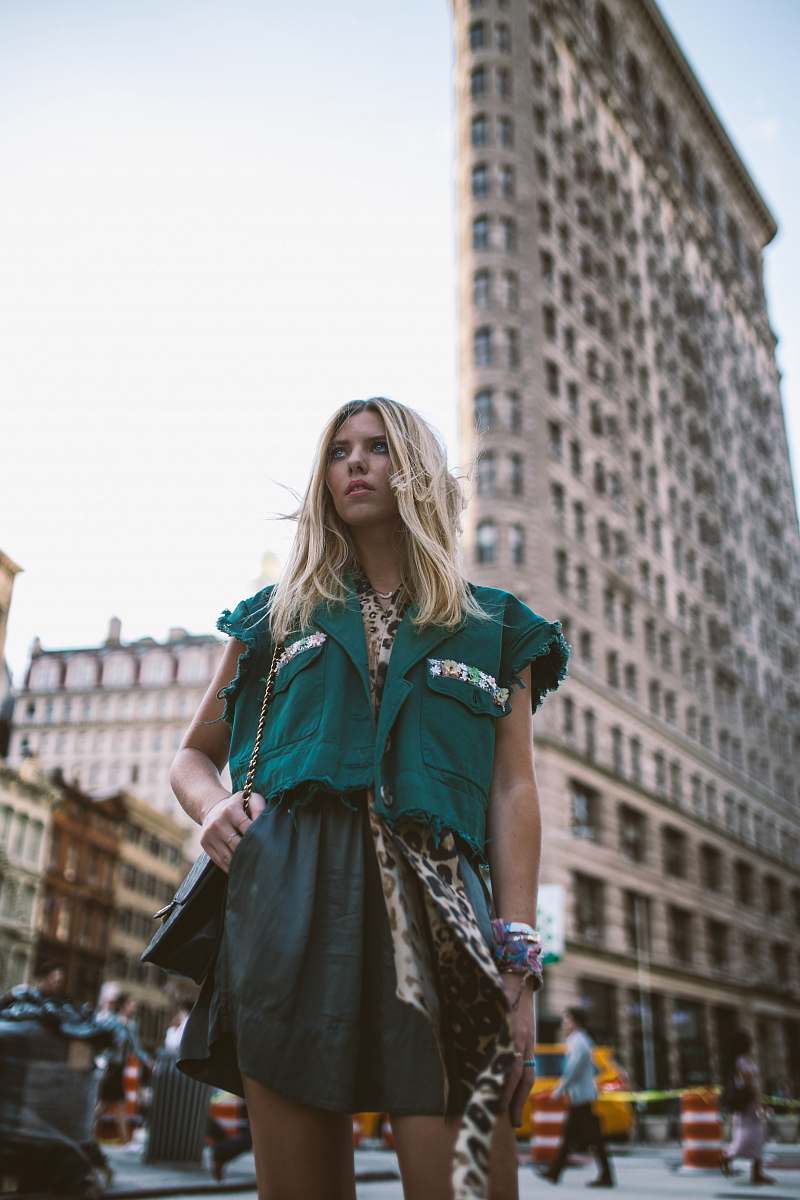 people woman wearing green top standing near Flatiron building human