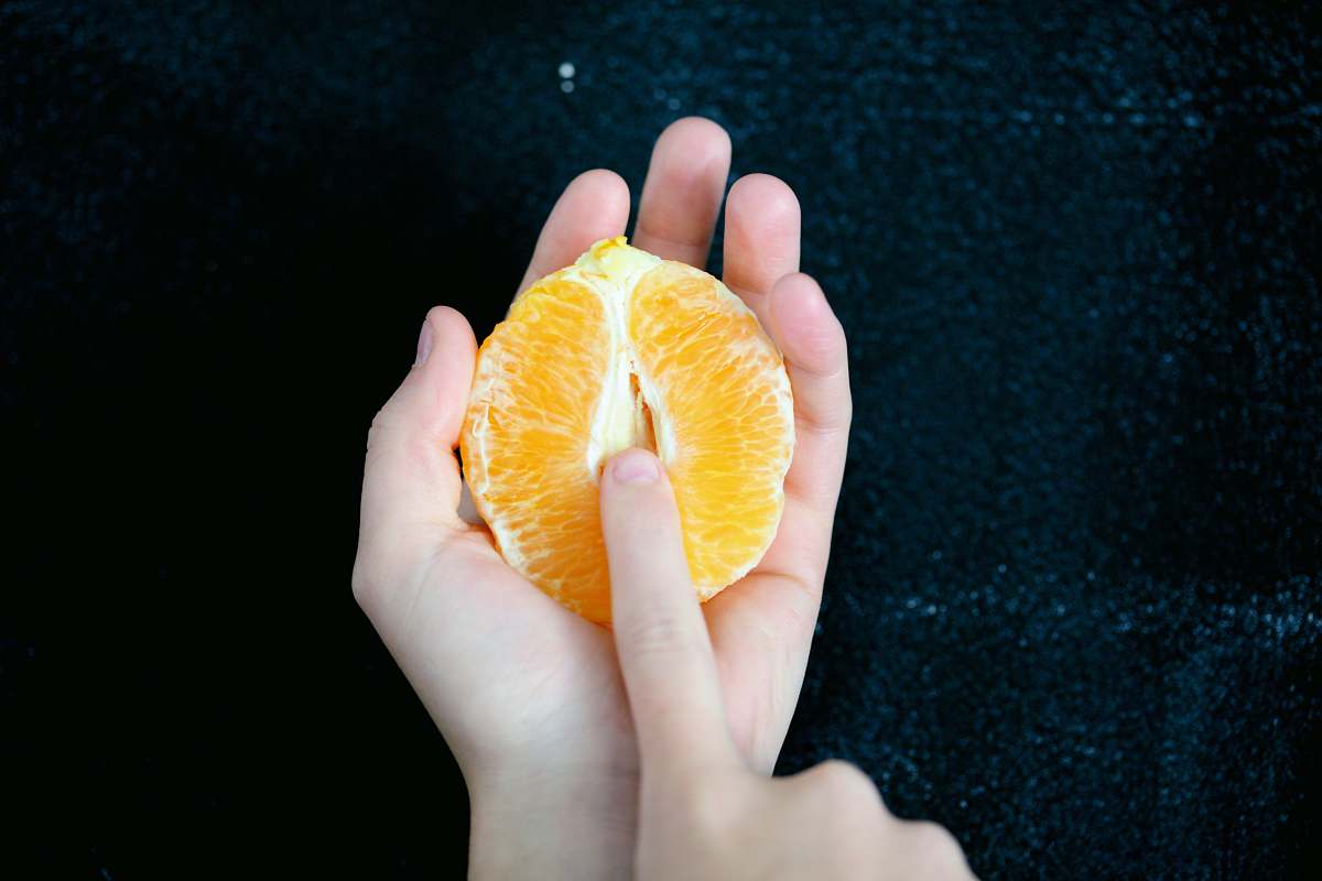 food person holding sliced orange fruit fruit
