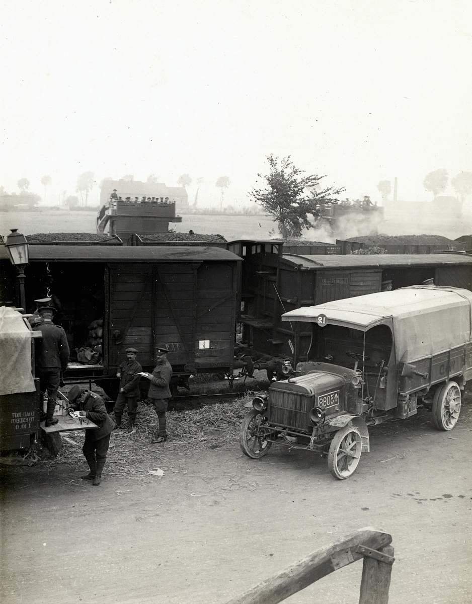 transportation greyscale photo of vehicles beside train truck