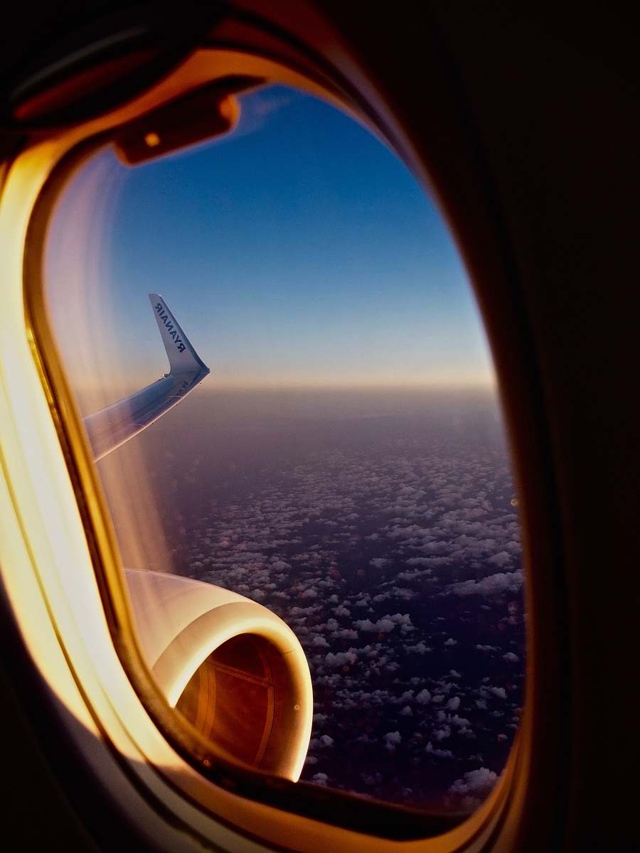 porthole white airliner during daytime flight