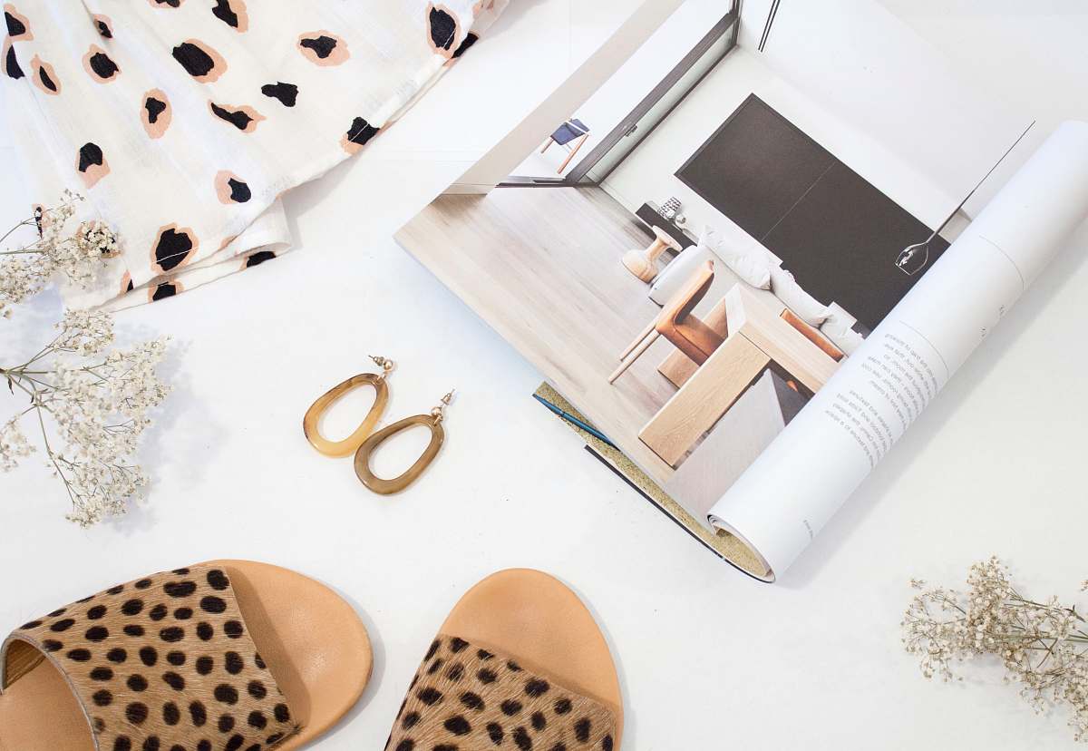 apparel sandals and earrings placed next to opened catalog fashion