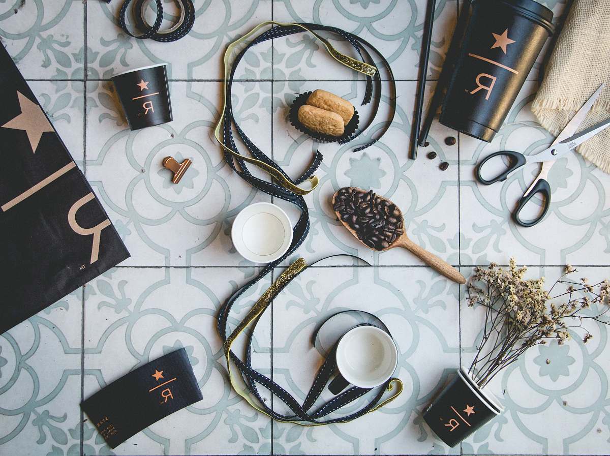 accessories brown and black straps near coffee beans and cups on gray tiles cup