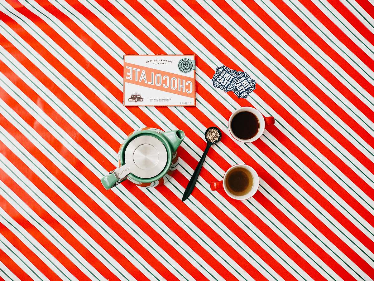 hole cup of coffee on red and white striped surface flat aly