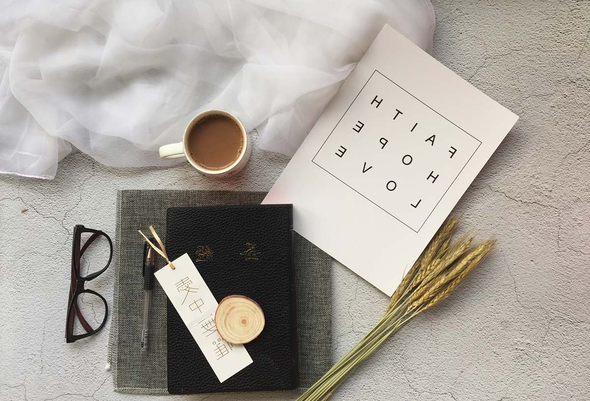 faith white ceramic mug near black-framed eyeglasses hope