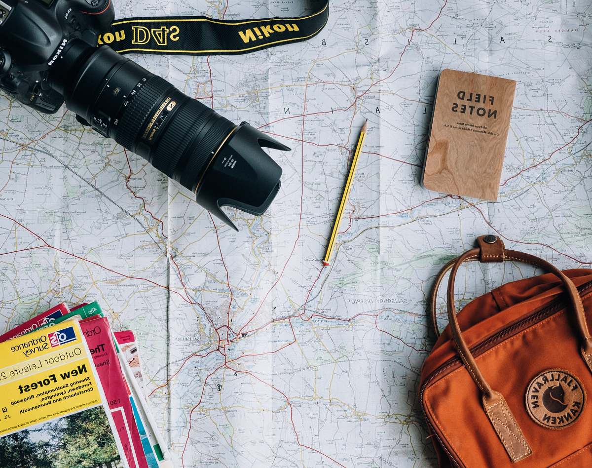 pencil flat lay photography of camera, book, and bag notebook