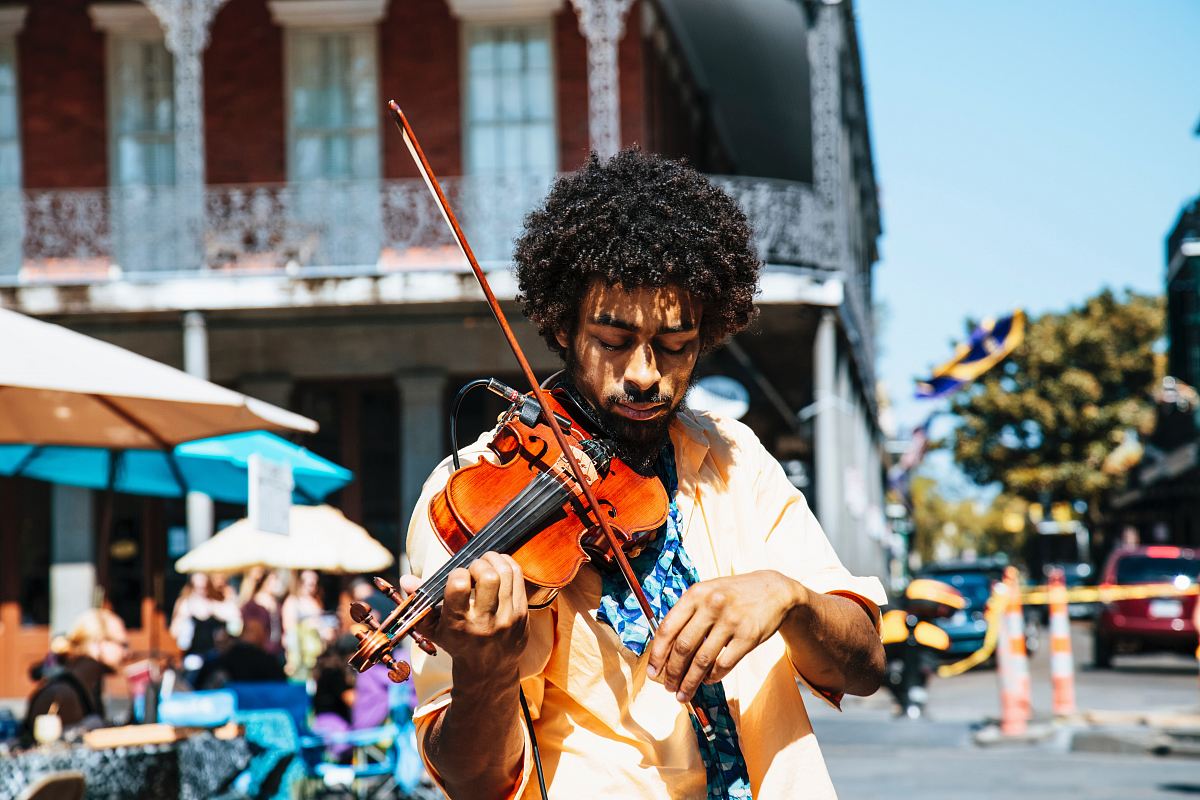 A man playing the violin or fiddle on the streets in New Orleans in the French Quarter
