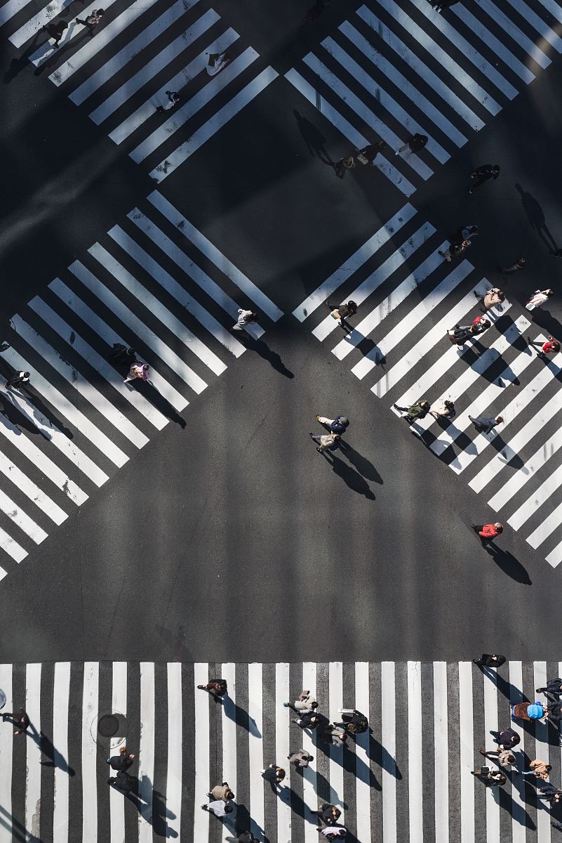 aerial photography of people walking in the intersection street during daytime