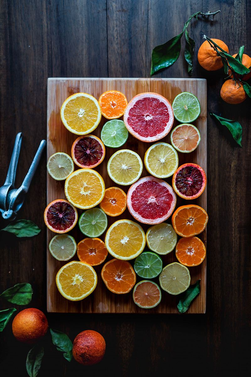 assorted sliced citrus fruits on brown wooden chopping board
