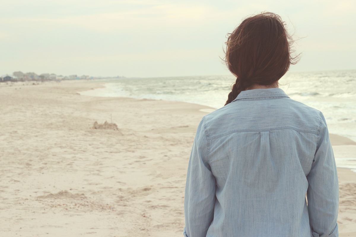 back view of woman standing near sea