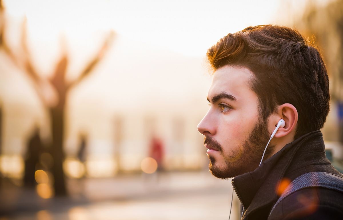 bokeh lights photography of man listening to in-ear earphones