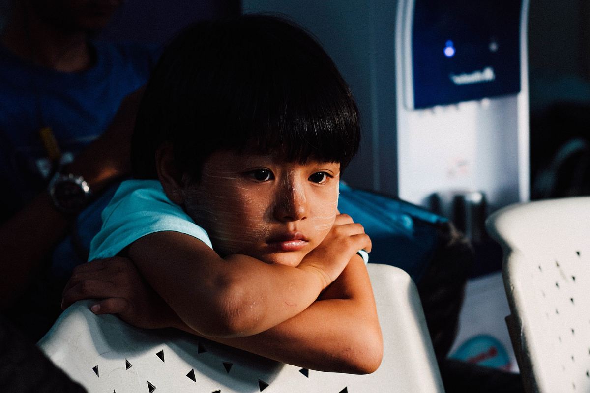 boy leaning on white chair