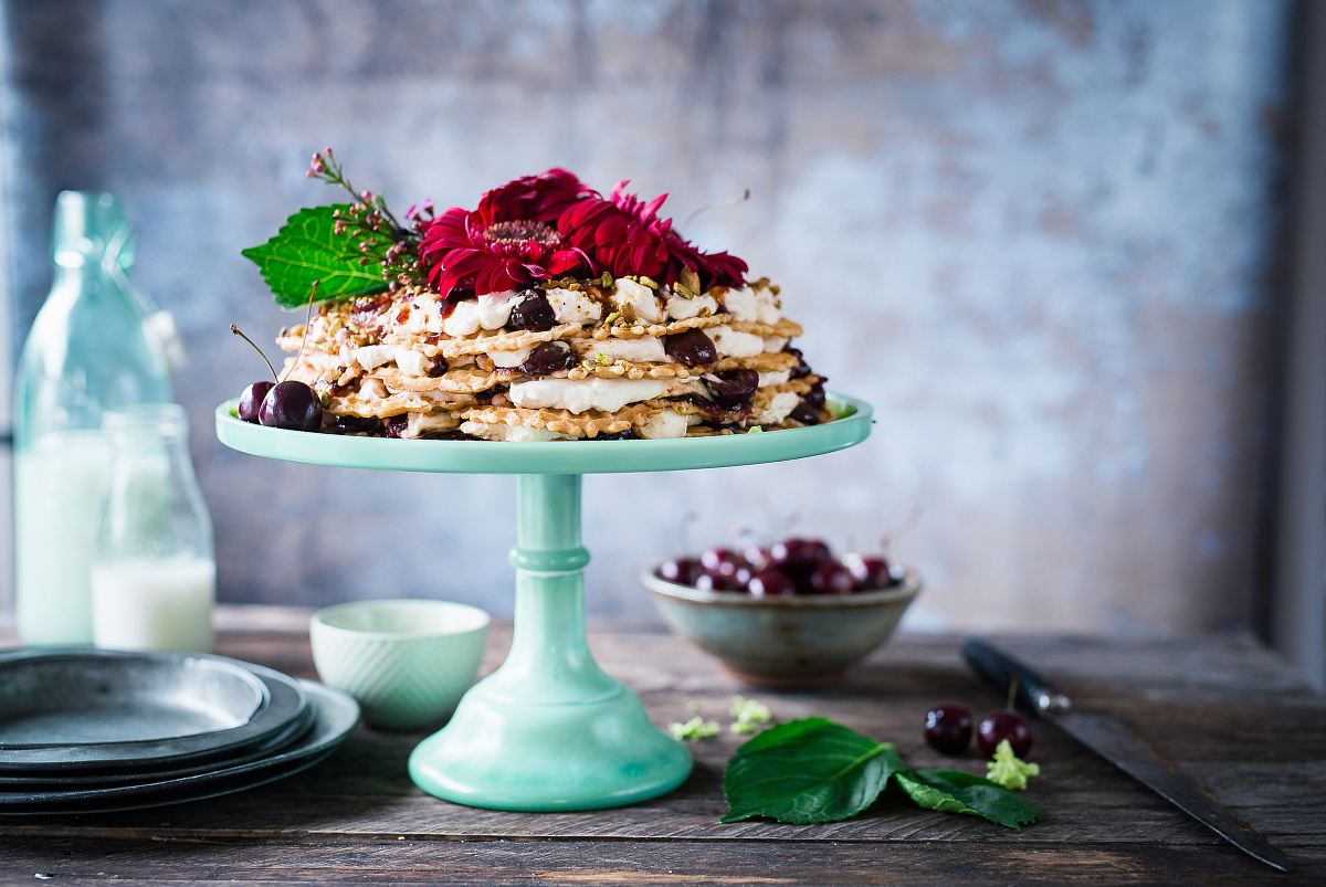 cake on cake stand beside milk on milk bottles
