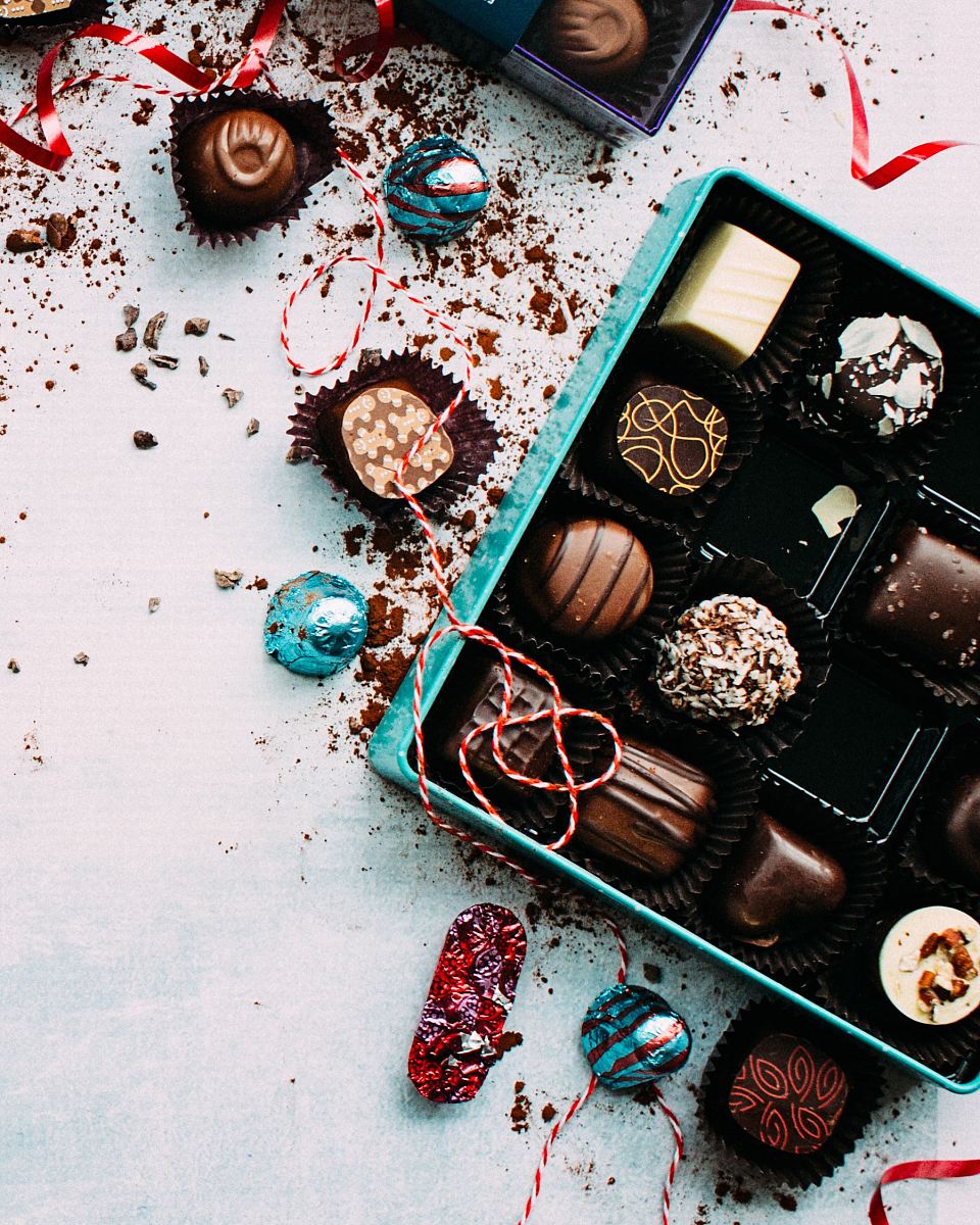 chocolates with box on white surface