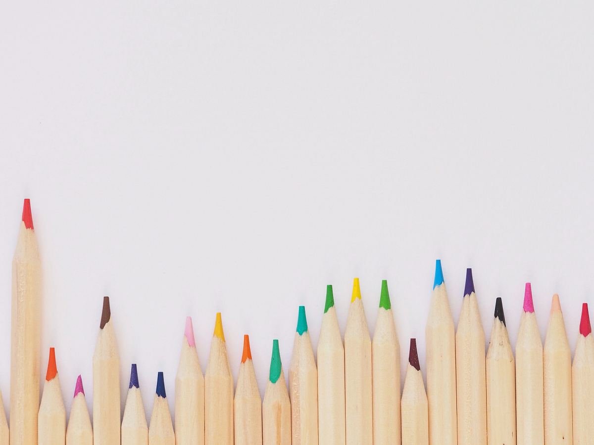colored pencil lined up on top of white surface