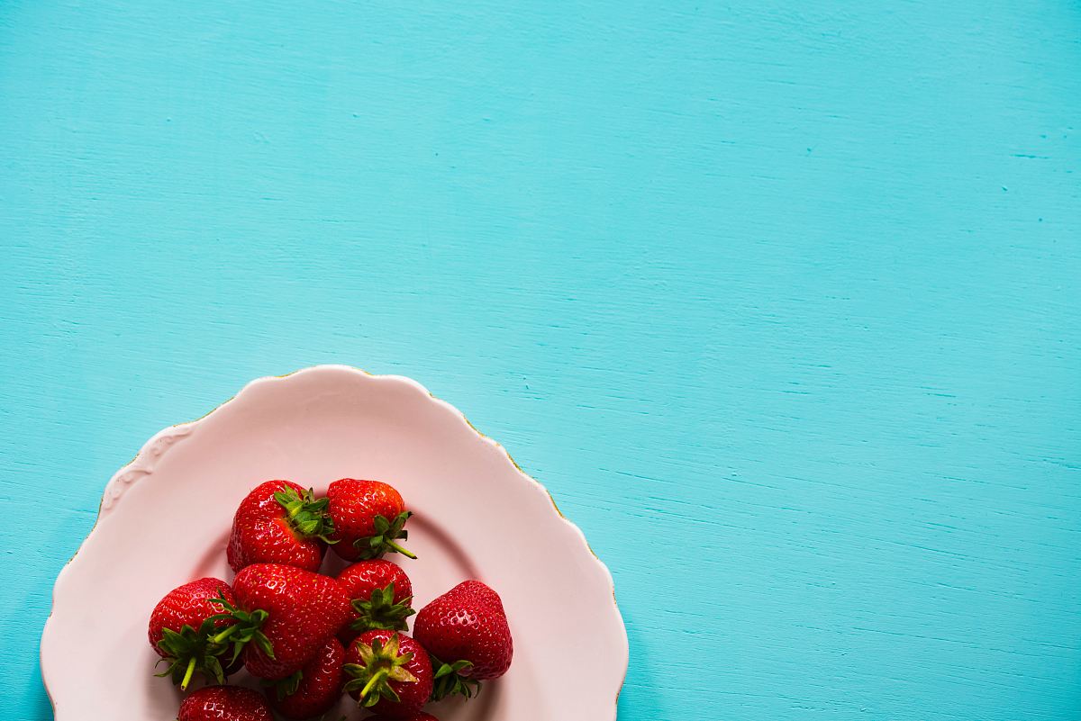 flat lay photography of bunch of strawberries on white plate