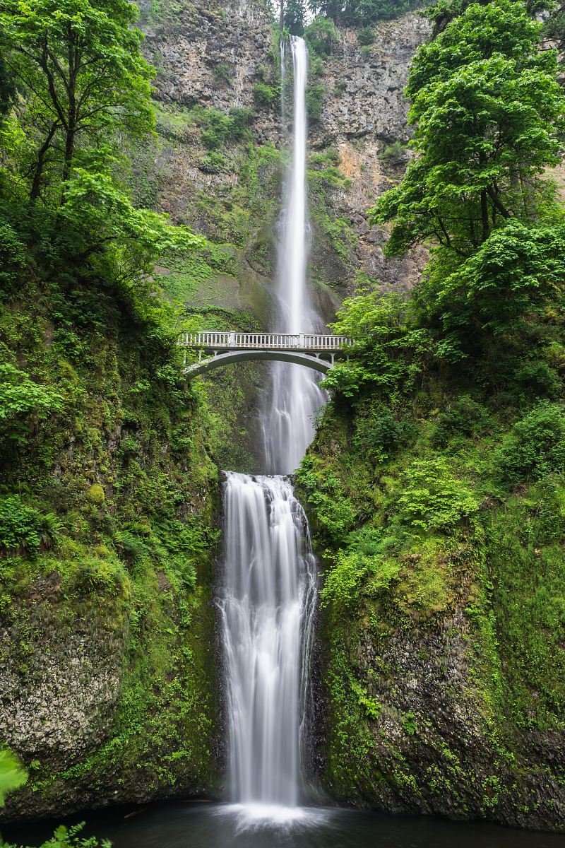 gray concrete bridge and waterfalls during daytime