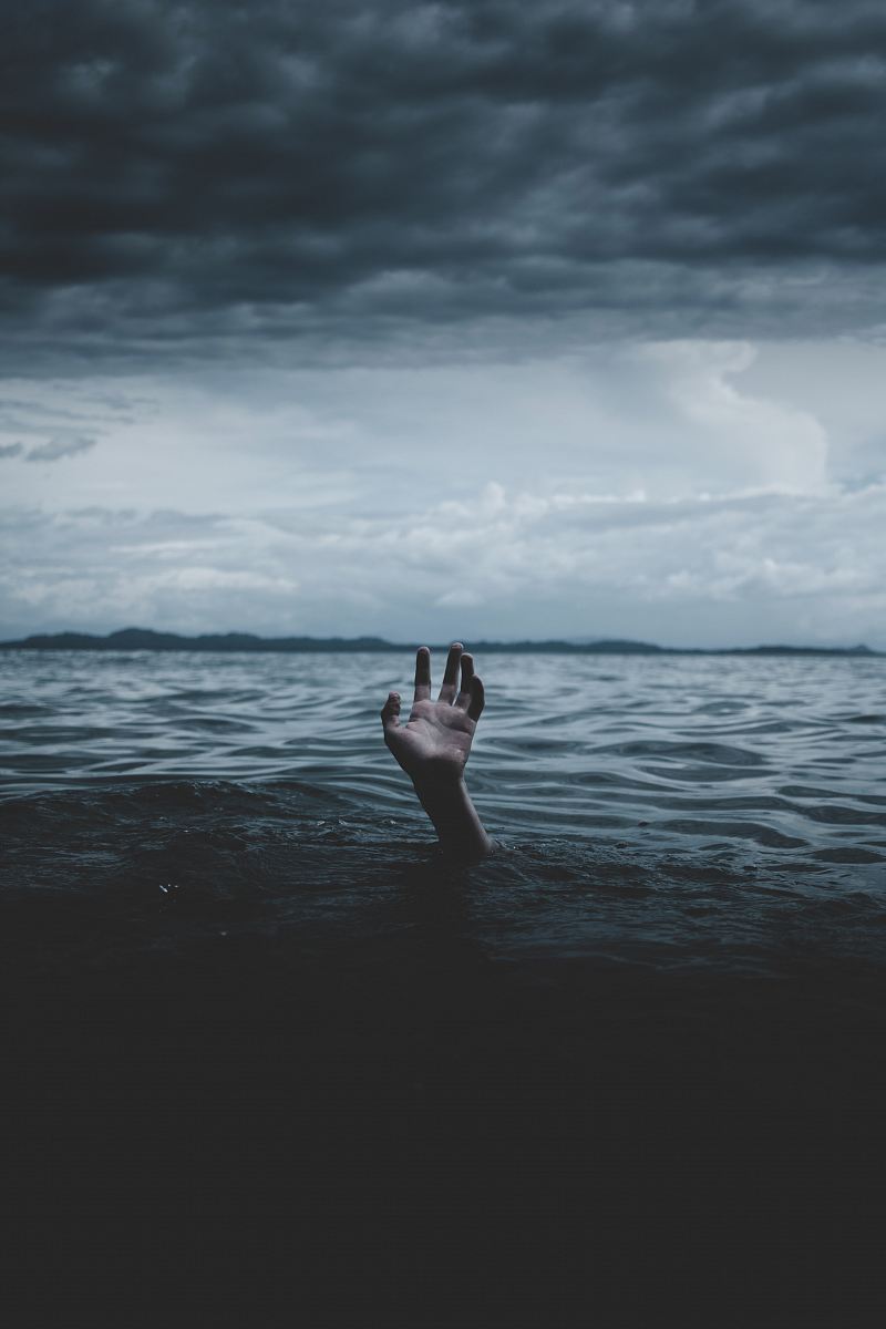 grayscale photography of hands under body of water