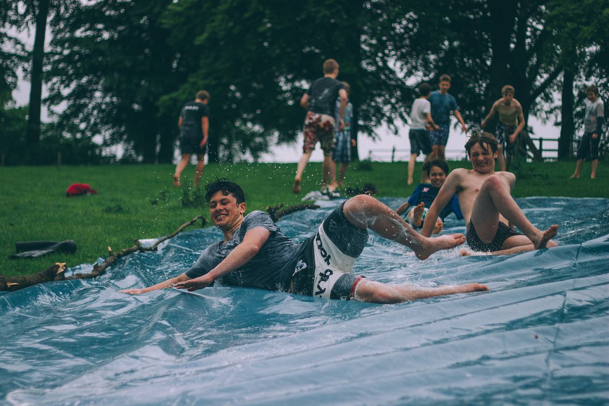 group of men sliding on blue canopy
