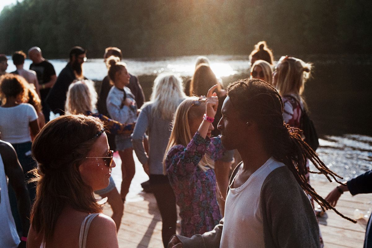 group of people standing on dock beside body of water