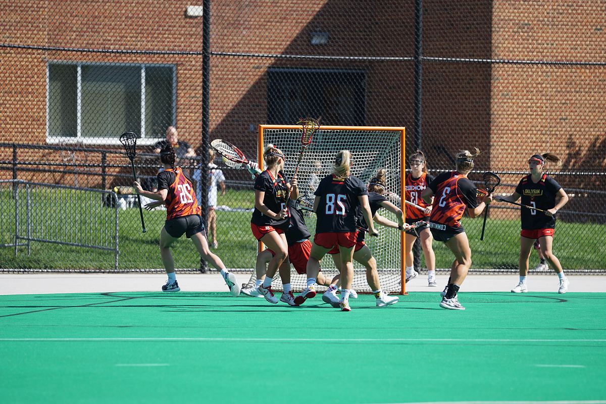 group of woman playing lacrosse during daytime