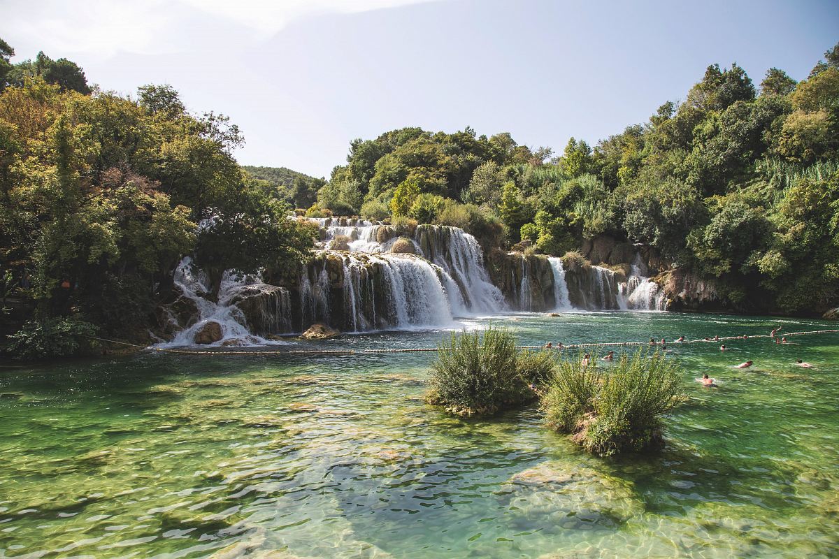 landscape photo of waterfalls flowing into river during daytime