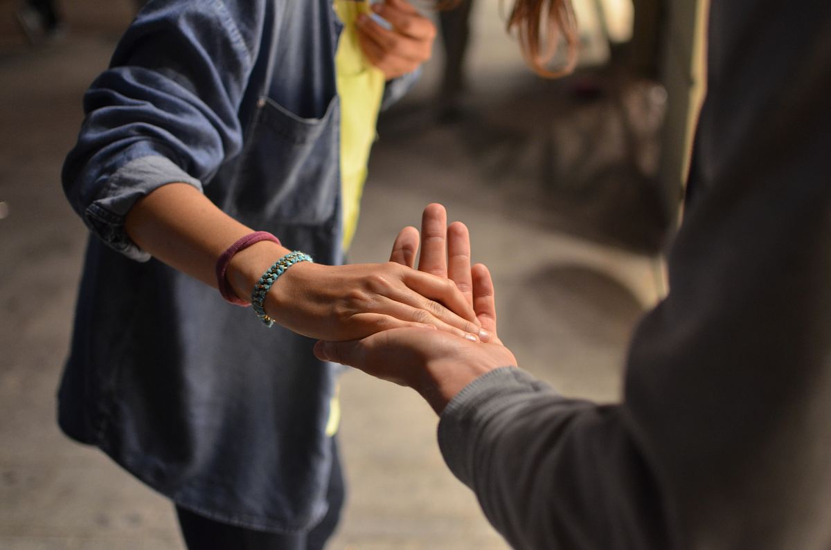 man and woman holding hands on street