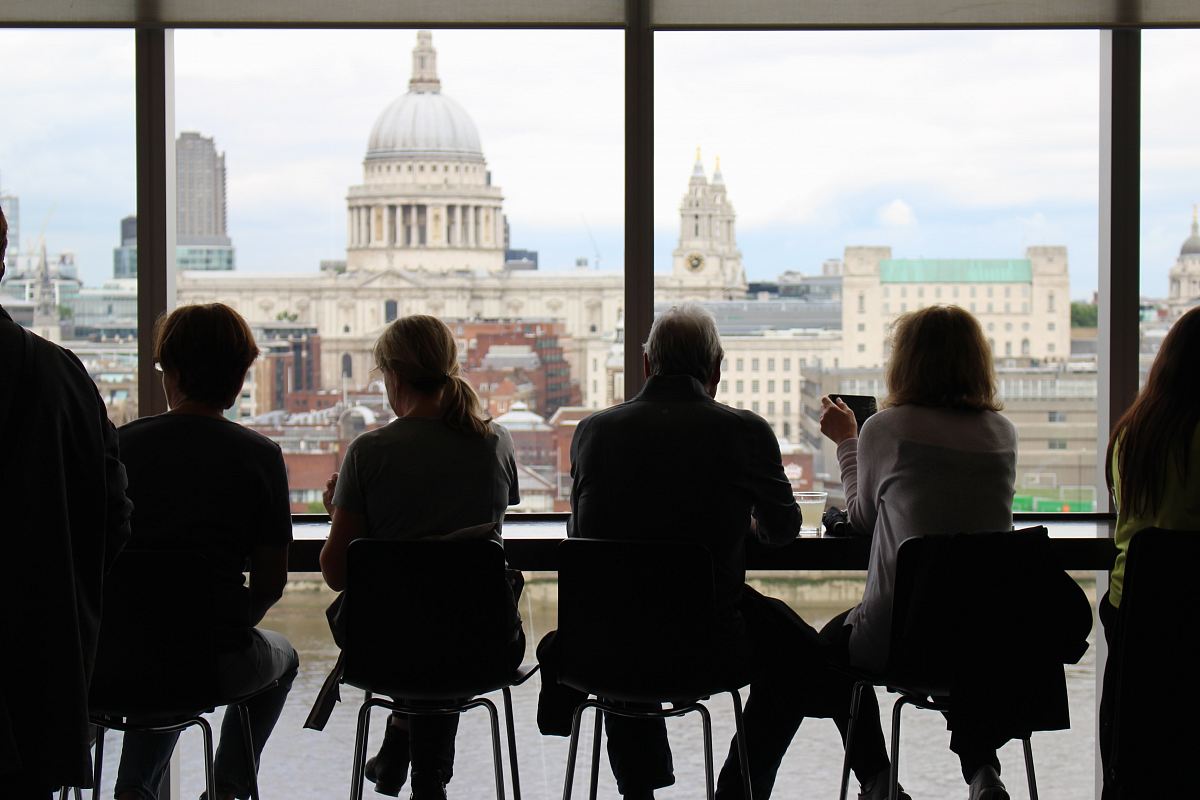 man in between of four women sits while watching on window