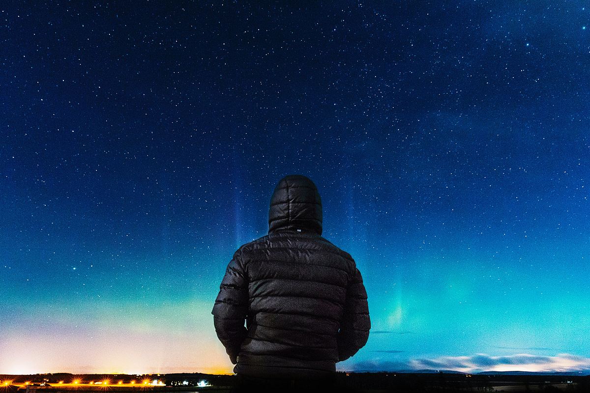 man in black bubble hoodie looking at the stars