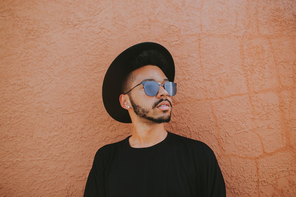 man leaning on brown wall