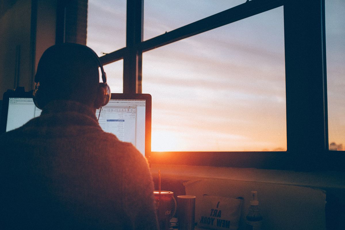 man sitting facing monitor