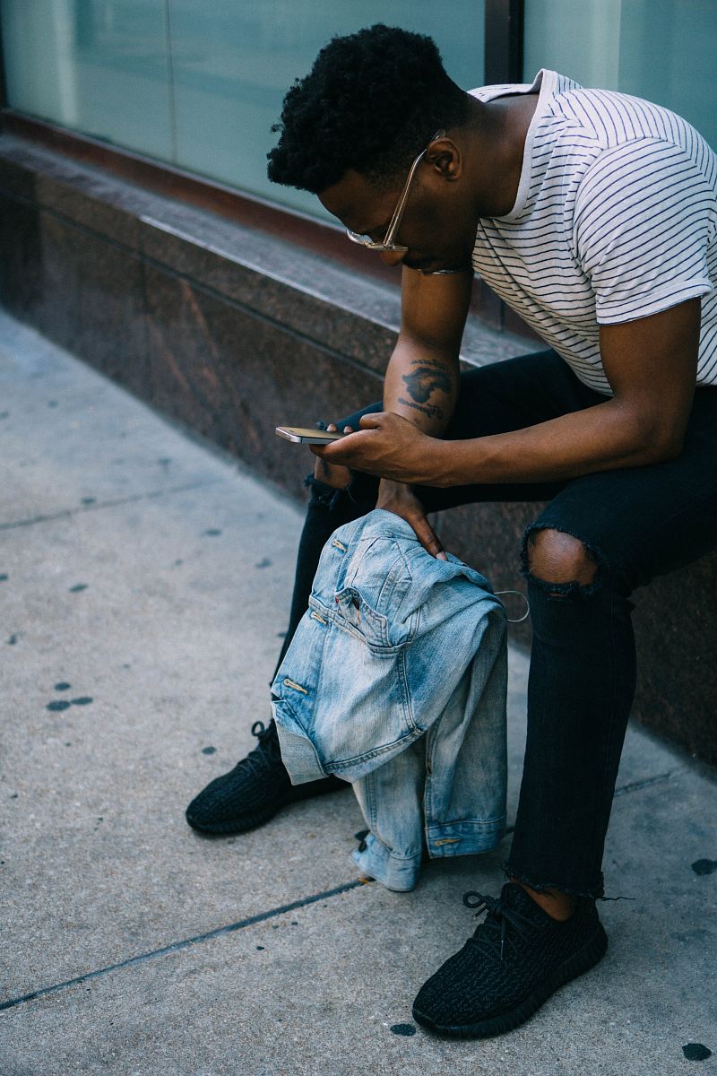 man sitting while using phone