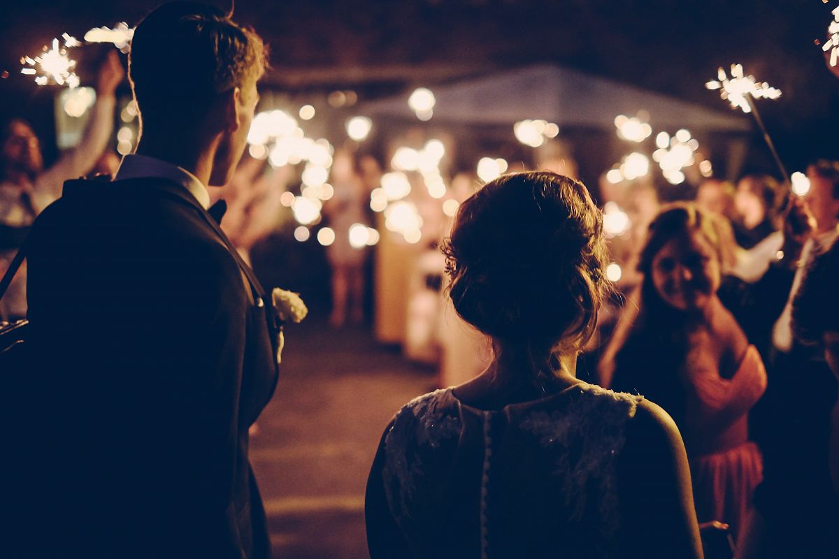 man standing near the woman walking in party during nighttime