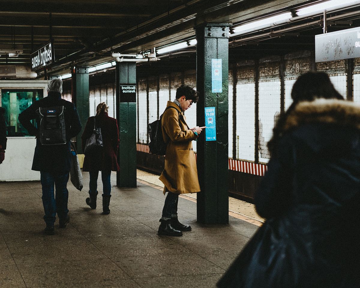 man using smartphone inside the train station