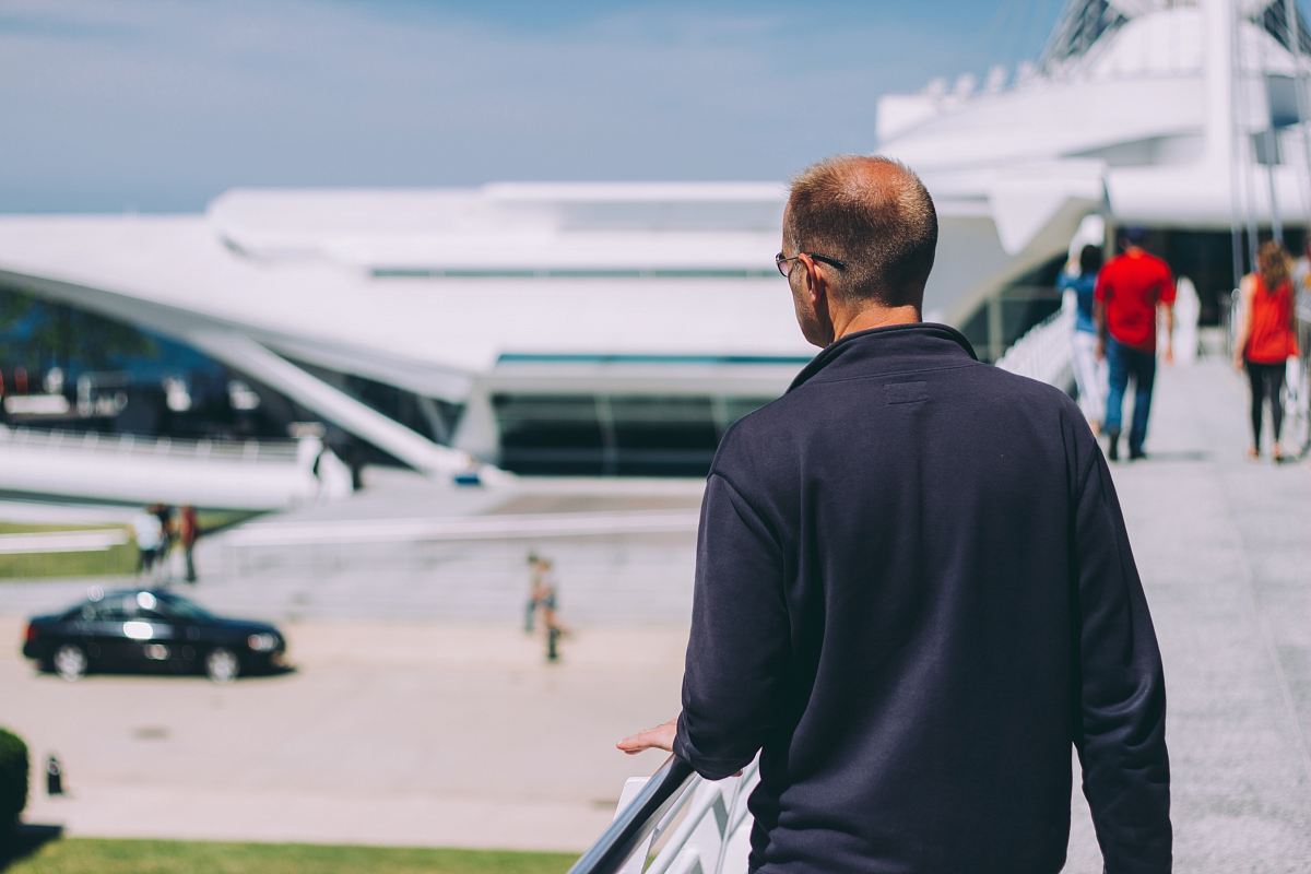 man wearing black jacket holding on handrail