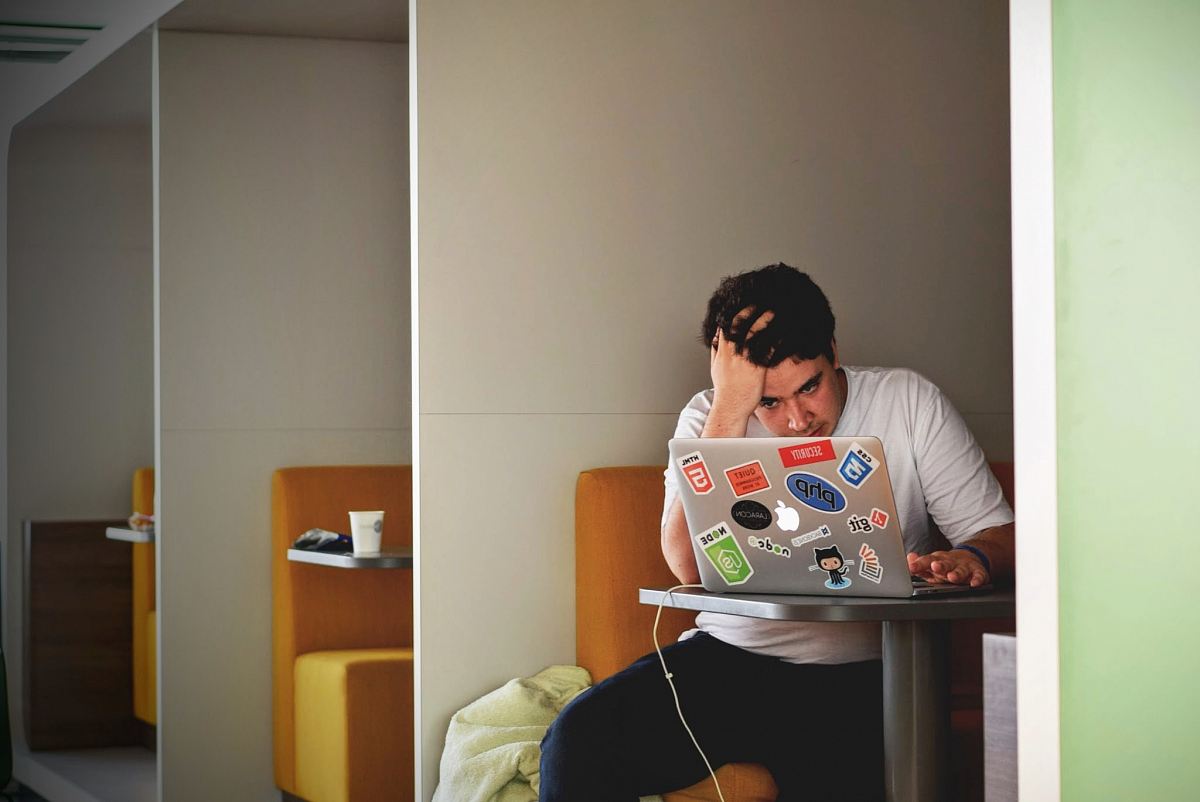 man wearing white top using MacBook
