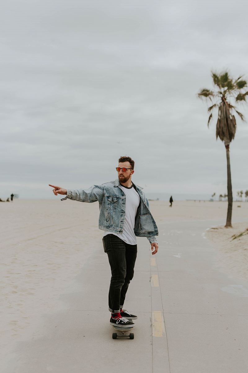 men's washed denim jacket riding a skateboard