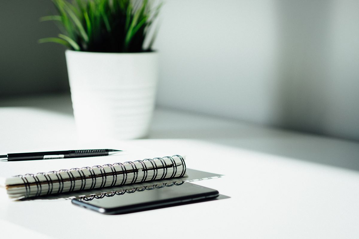 pen, notebook, and smartphone on table