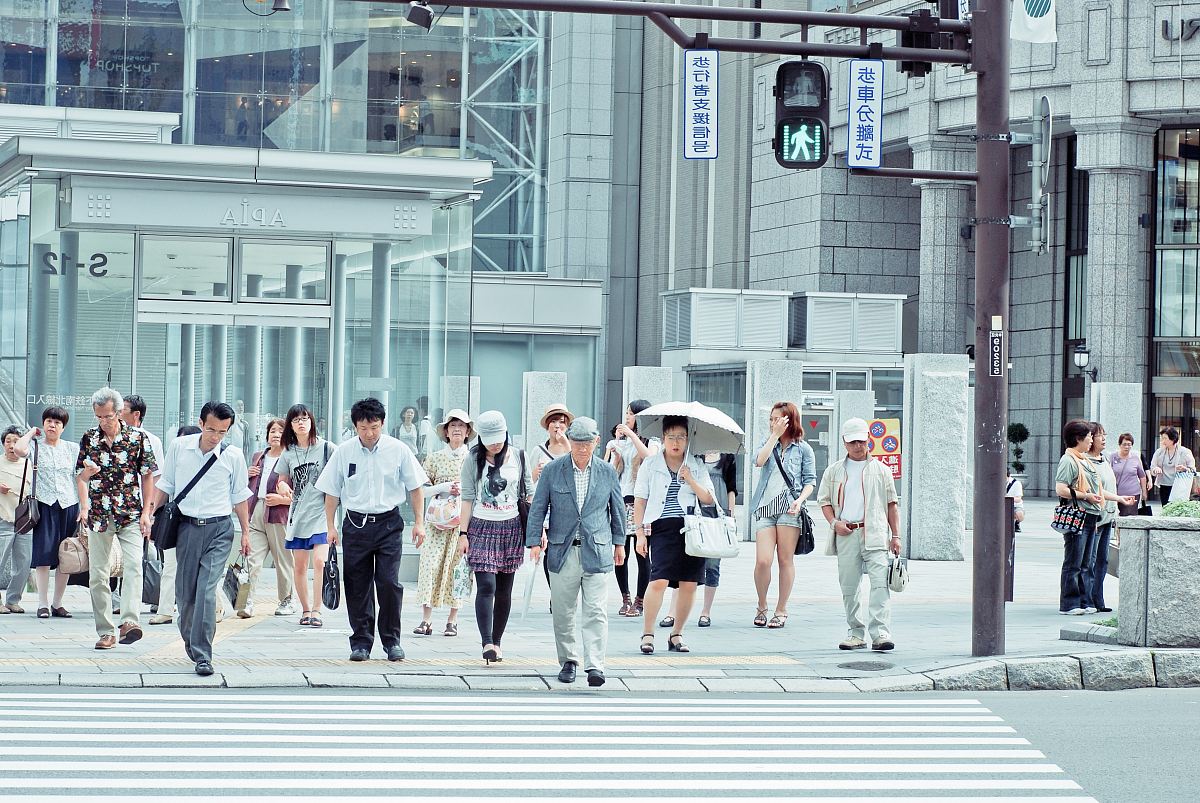 people crossing pedestrian lane near building at daytime