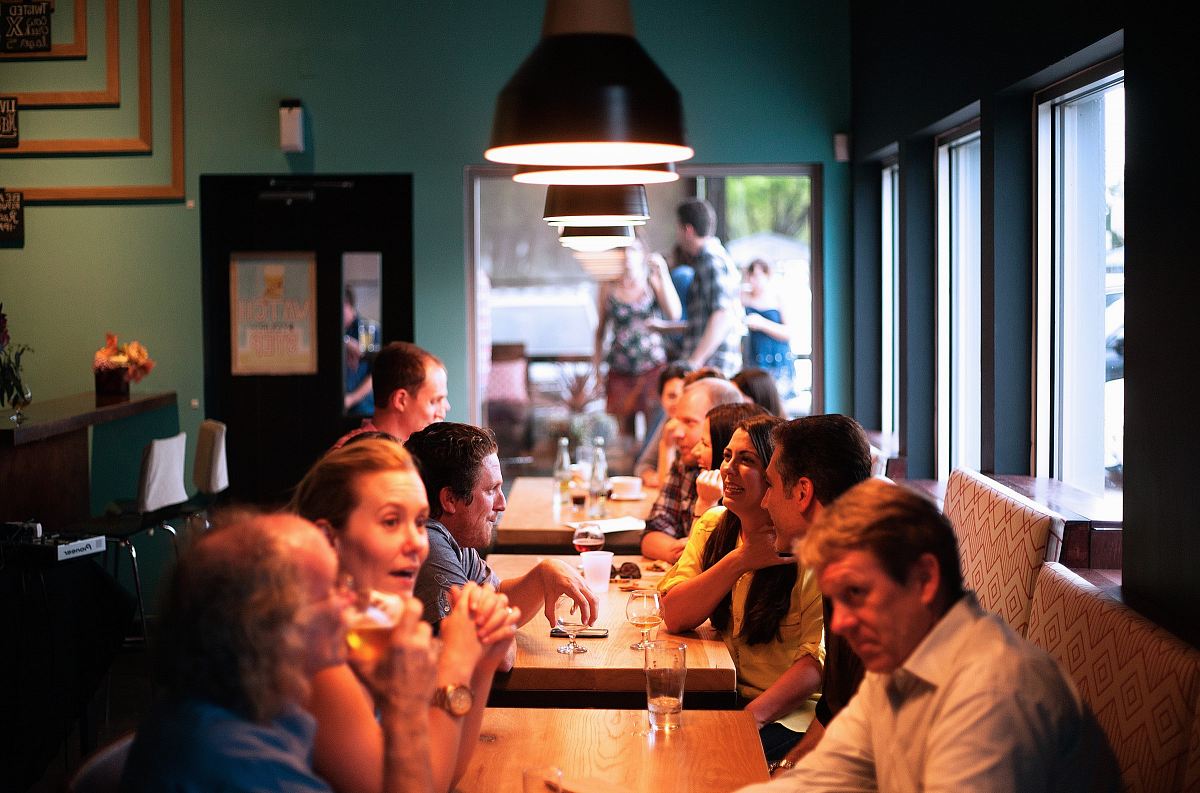 people sitting beside brown wooden table inside room