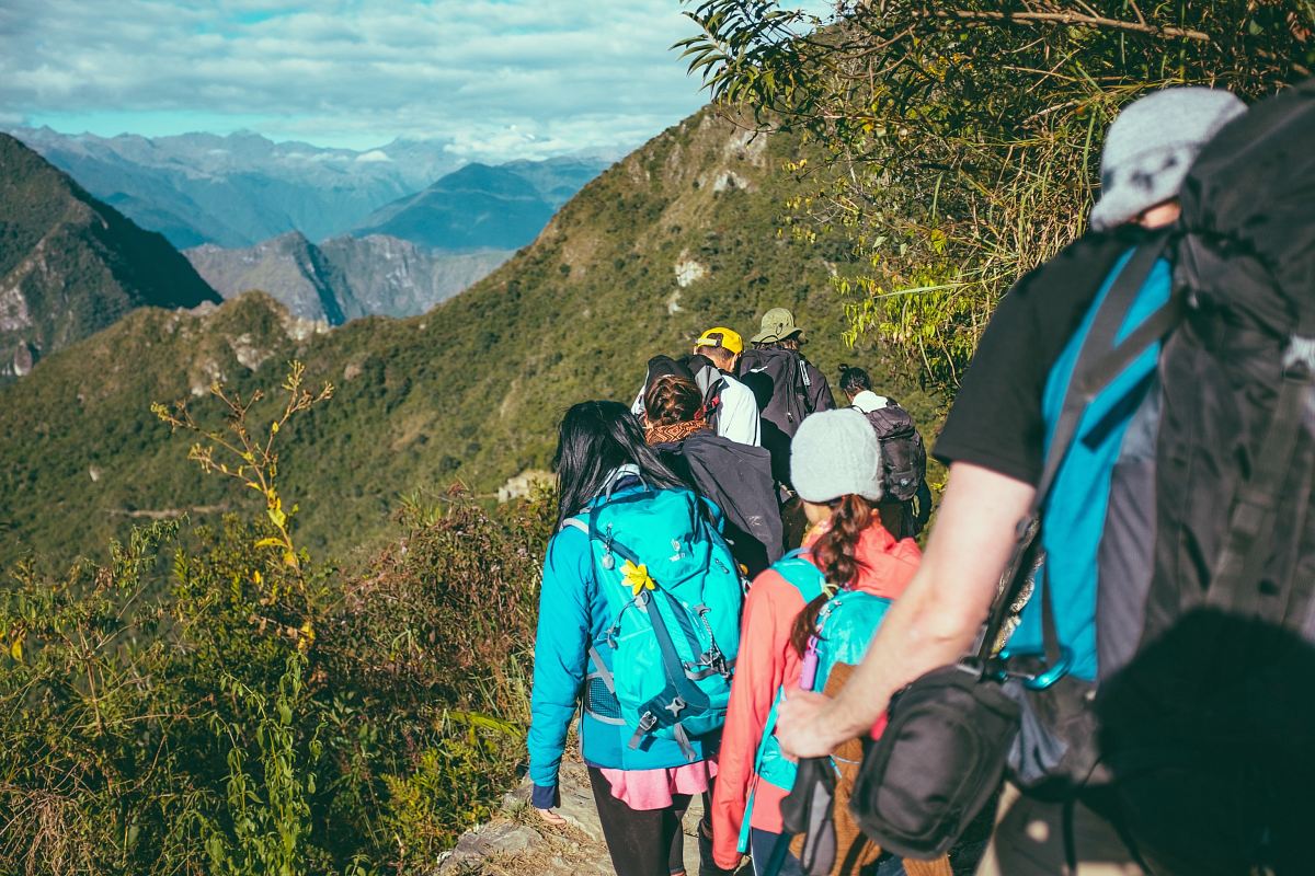 people walking beside the mountain