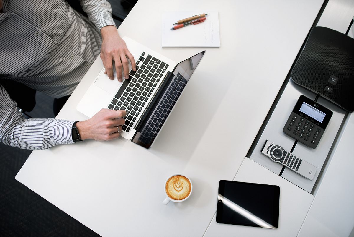 person using laptop on white wooden table