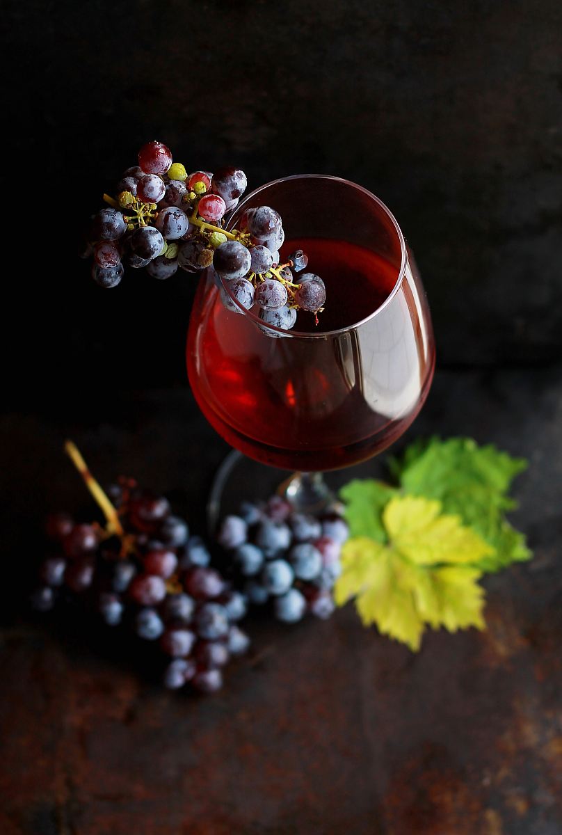 red grapes on clear glass wine