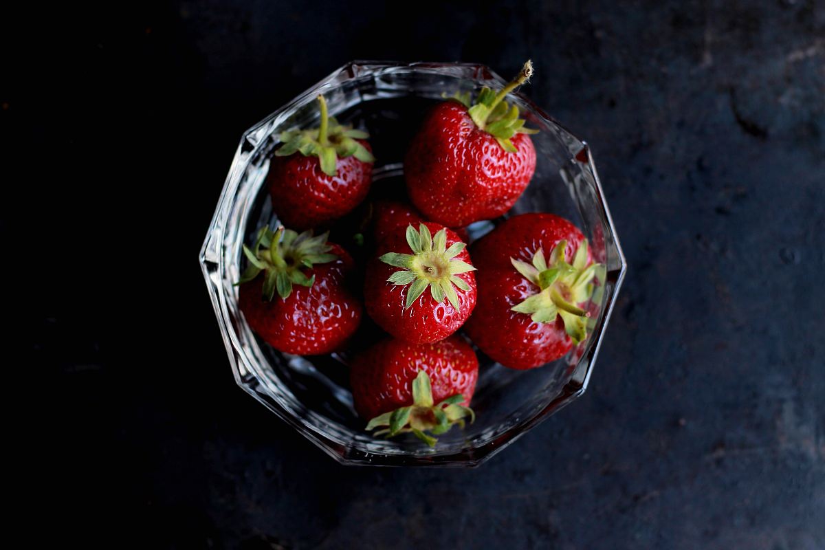 red strawberries in clear glass bowl