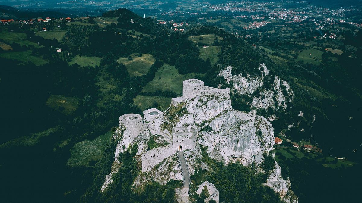 rock formation with concrete building high-angle photography