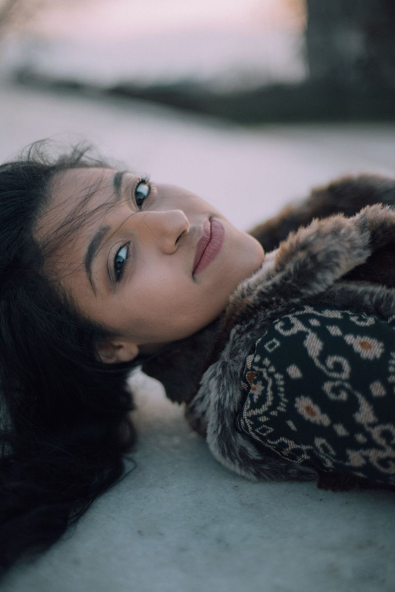 selective focus photo of woman lying on ground smiling