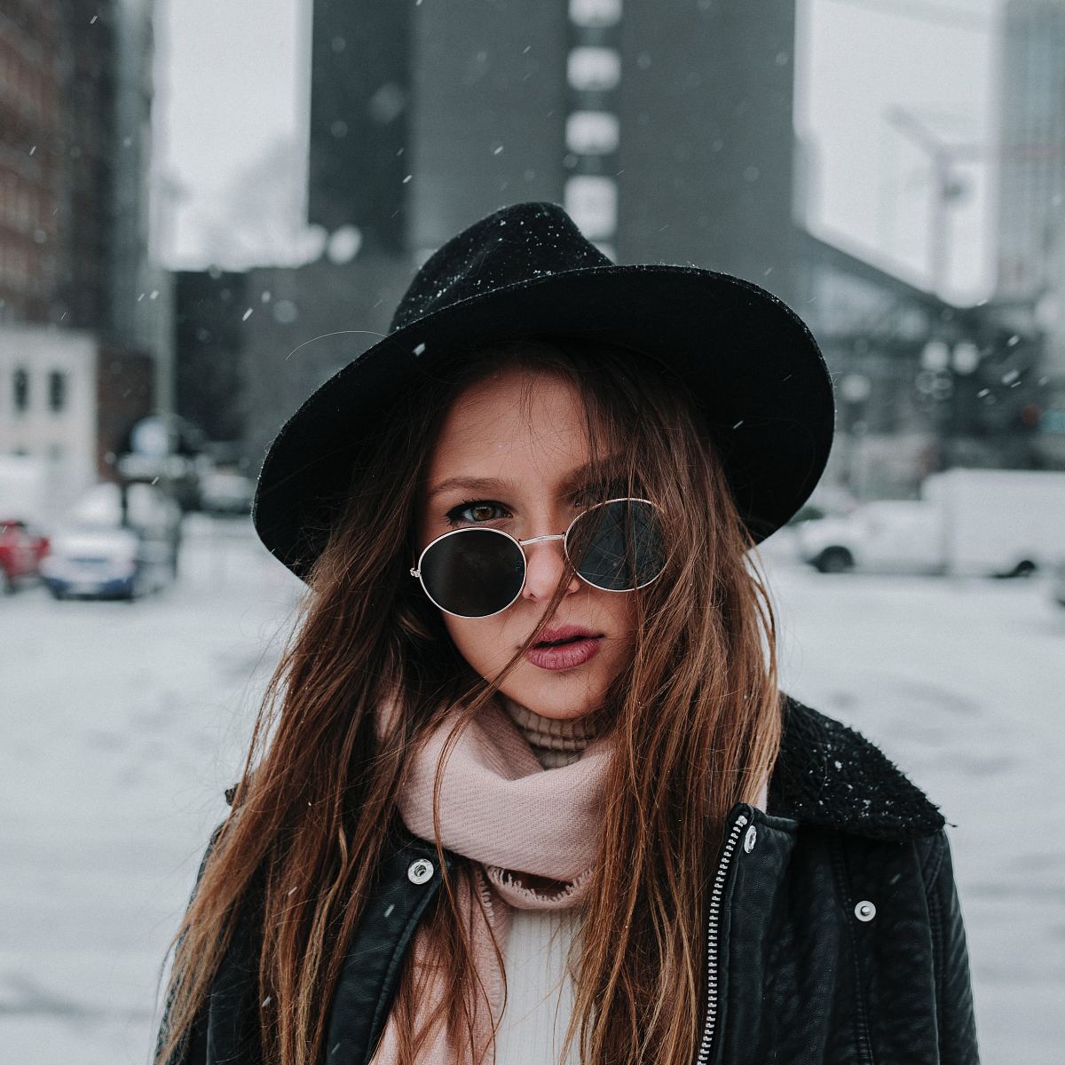 shallow focus photography of woman wearing hat while snowing